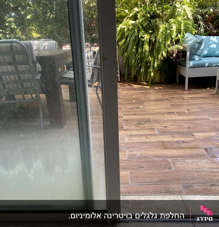 דלת זכוכית עם מסגרת מתכתית על מסילה